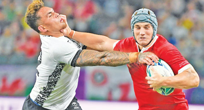 Brilliant Adams grabs hat-trick as battered Wales reach quarters